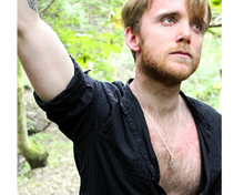 Load image into Gallery viewer, A man wearing a silver necklace with a leaf and small corked bottle of smokey quarts crystals.
